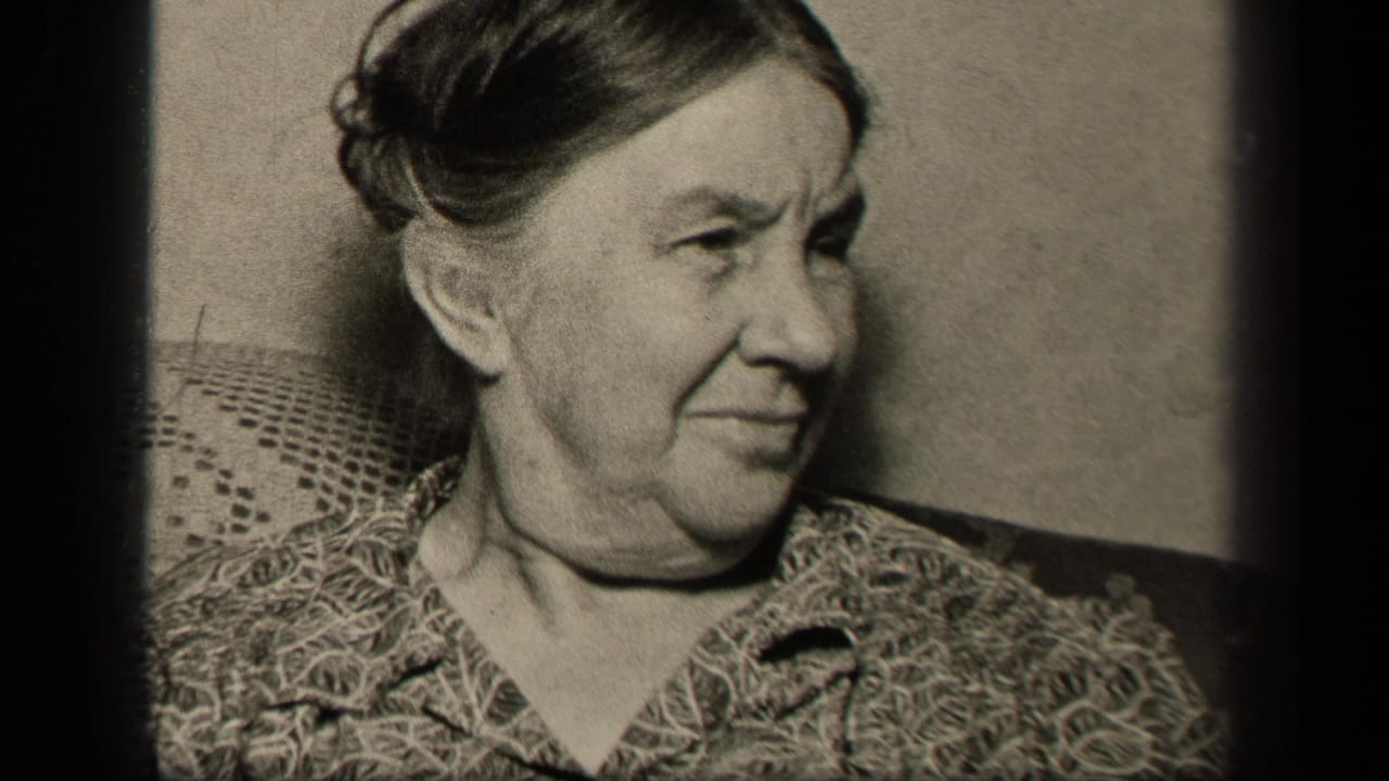 Elderly woman turns her head to the side while seated indoors.