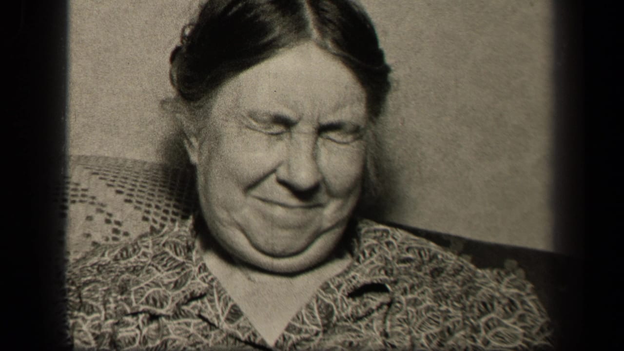 In Sebring, Ohio 1942 home-movie footage, an older woman in a patterned blouse sits on a textured couch with her eyes shut.