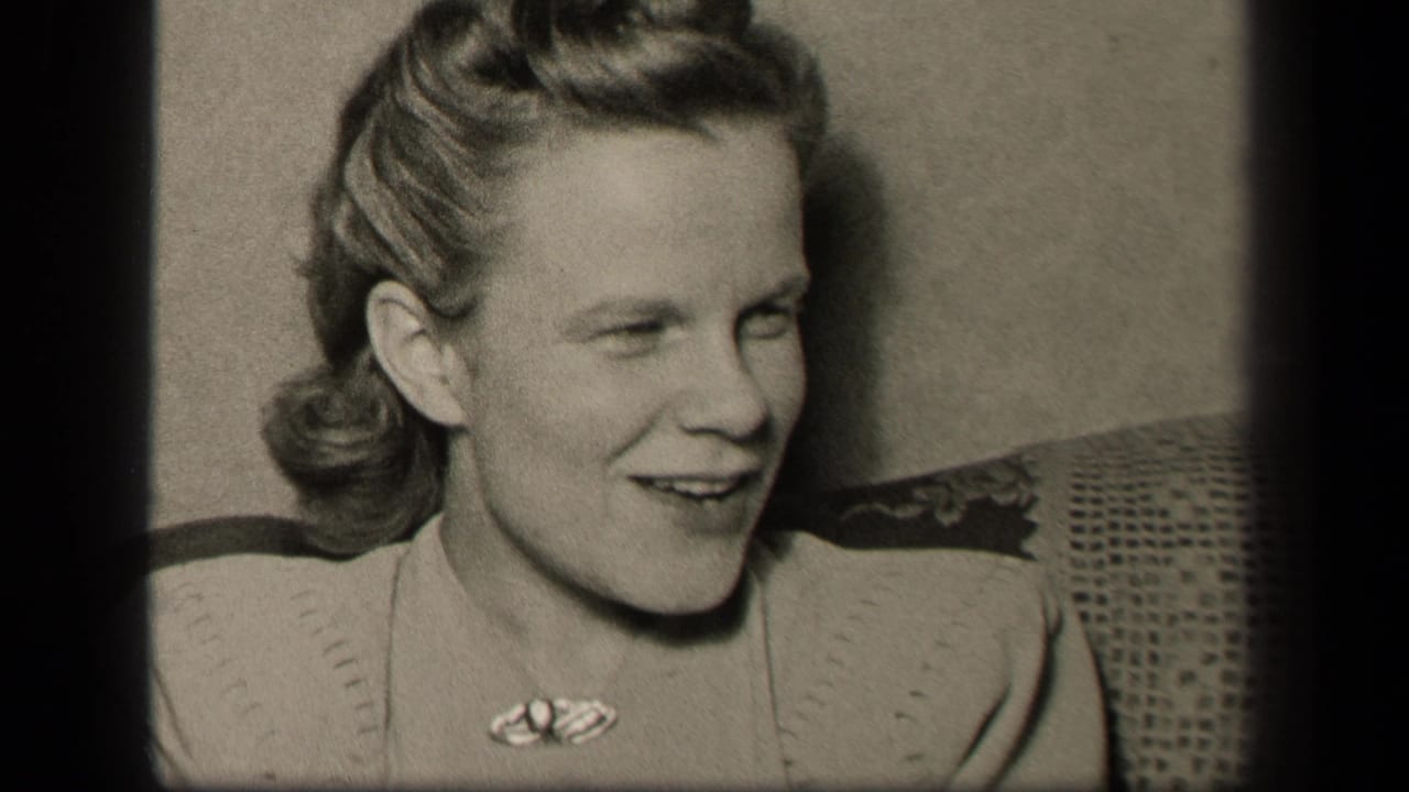 Young woman turned slightly to the side, smiling on a couch.