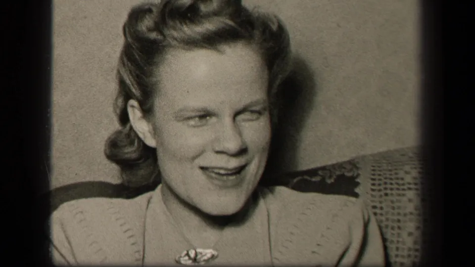 The woman faces forward again with a softer smile, framed closely in black-and-white 8mm footage from the supplied 1942 Sebring metadata.