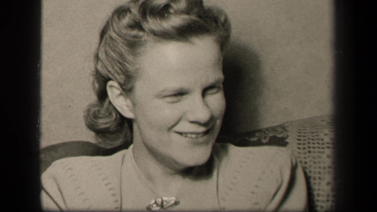 A woman in 1942 Sebring, Ohio home-movie footage smiles and looks off-camera from a seated interior position.