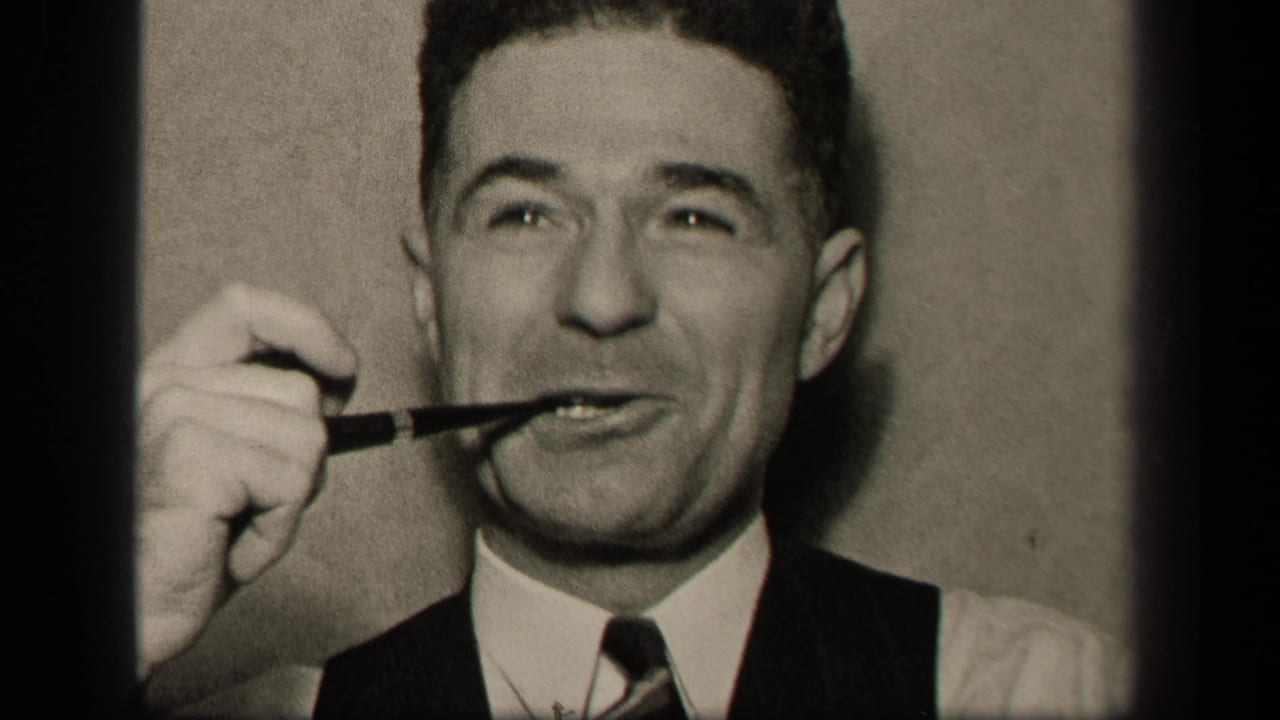 In 1942 Sebring, Ohio home-movie footage, an adult man in a vest and tie holds a pipe at his mouth and glances upward.