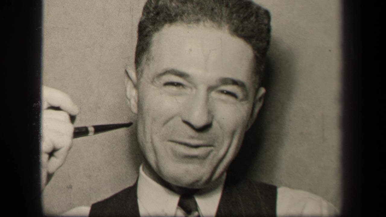 The Sebring, Ohio 1942 frame shows the man facing the camera with a pipe raised beside his cheek, wearing a white shirt, tie, and dark vest.