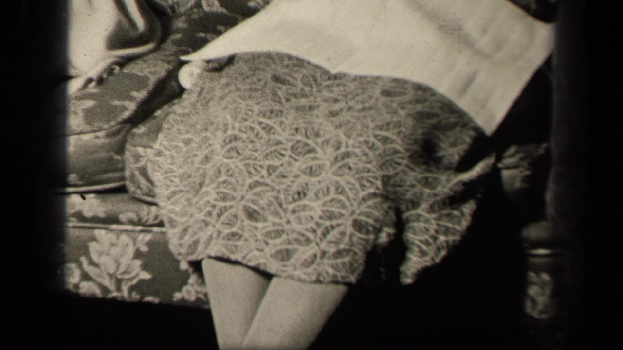 1942 Sebring, Ohio frame showing a woman seated on a floral couch with a textured skirt and white napkin across her lap.