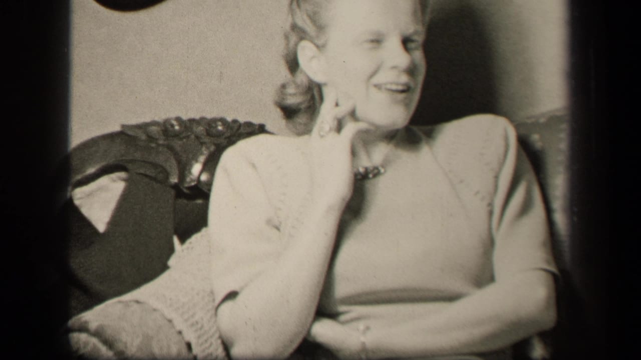 Woman in 1940s dress sits in an ornate chair in Sebring, Ohio, smiling with her hand raised near her cheek.
