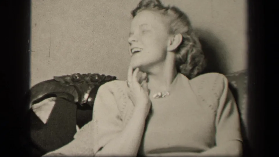The woman looks upward and smiles in the ornate chair, a brief 1942 Sebring, Ohio domestic home-movie moment.