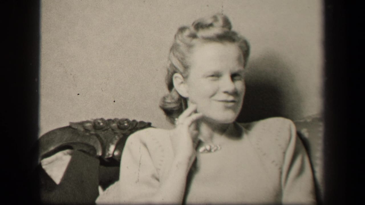 In 1942 Sebring, Ohio home-movie footage, the seated woman smiles toward the camera while resting her hand near her neck.