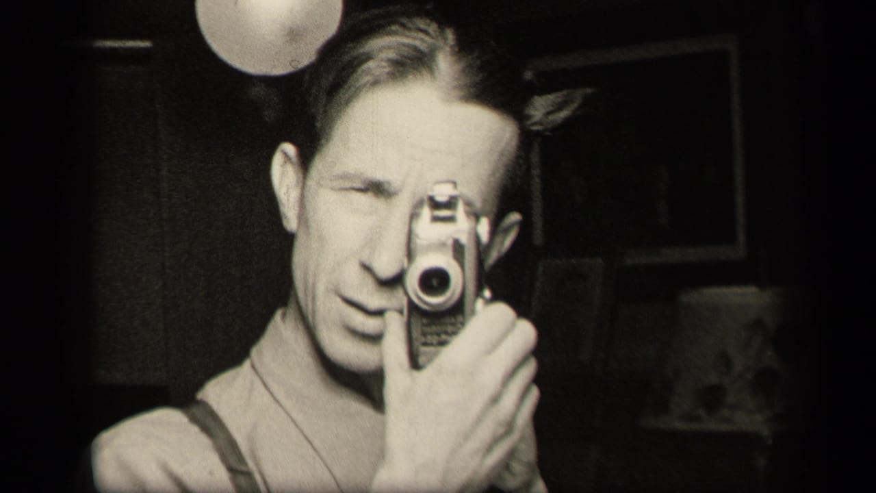 The man continues filming his mirror reflection, with the camera obscuring one eye in the dim 1942 Ohio interior.