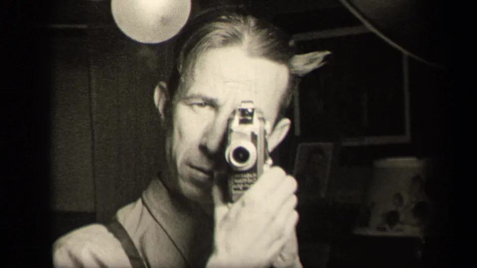 The final frame catches the man looking more directly toward the mirror as he records himself with the 8mm camera.