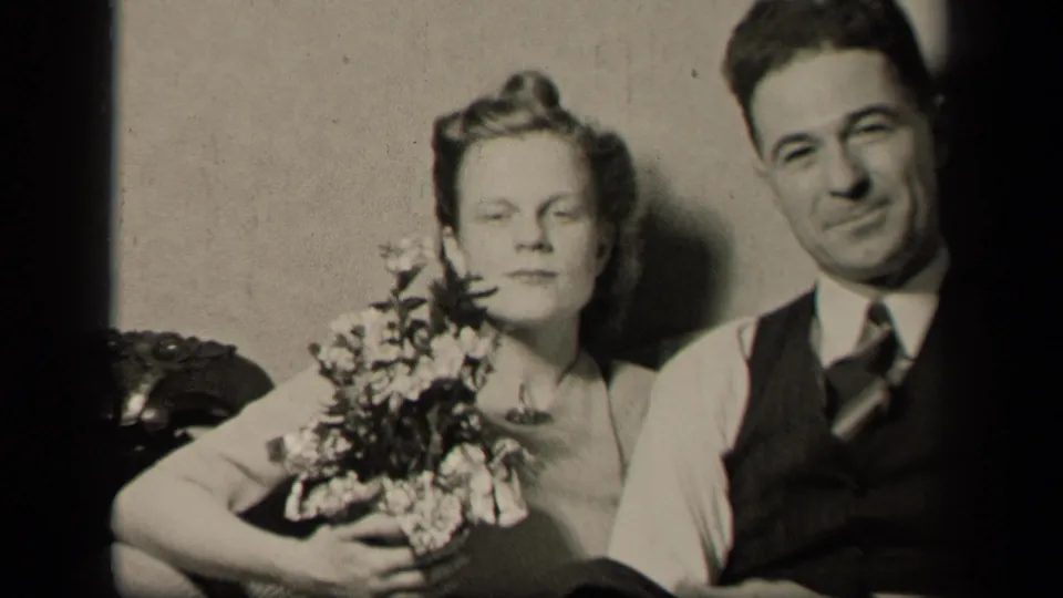 1942 Sebring, Ohio home-movie frame showing a bride with flowers seated beside her groom as they face the camera.