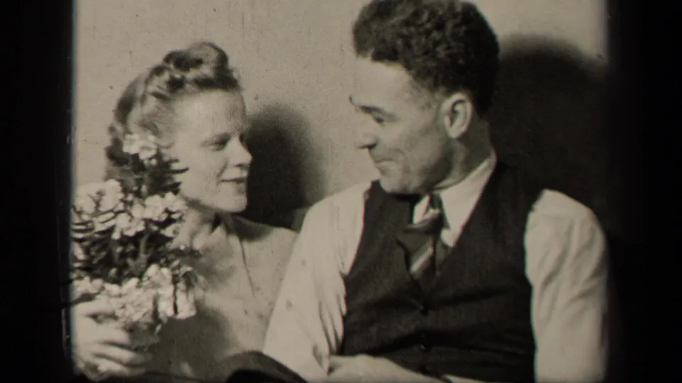 The woman with a bouquet turns toward the man beside her in the 1942 Sebring, Ohio home-movie frame.