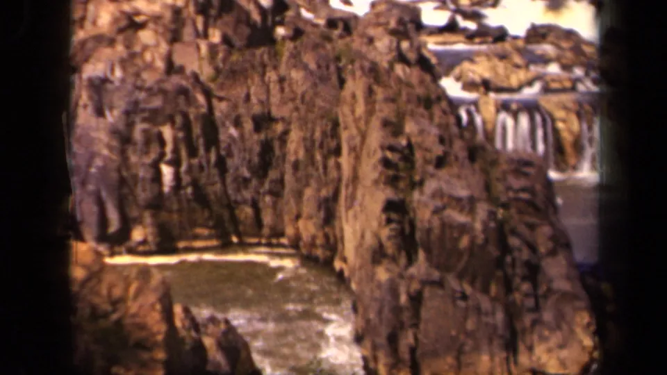 1943 8mm home-movie view of a tall rock wall, white cascade and darker water below in the Baltimore, Maryland area.