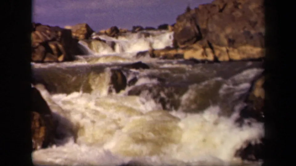 1943 8mm frame showing foamy water moving through rocks below a low cascade in the Baltimore location metadata.