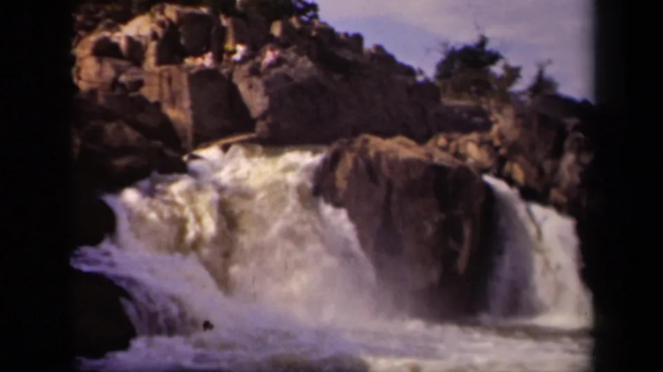Turbulent water surges around a large rock in this 1943 Baltimore-area waterfall view from an 8mm home movie.