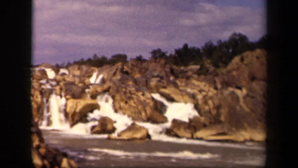 Wide 1943 8mm view of multiple small cascades and rapids running through a rocky gorge near Baltimore, Maryland.