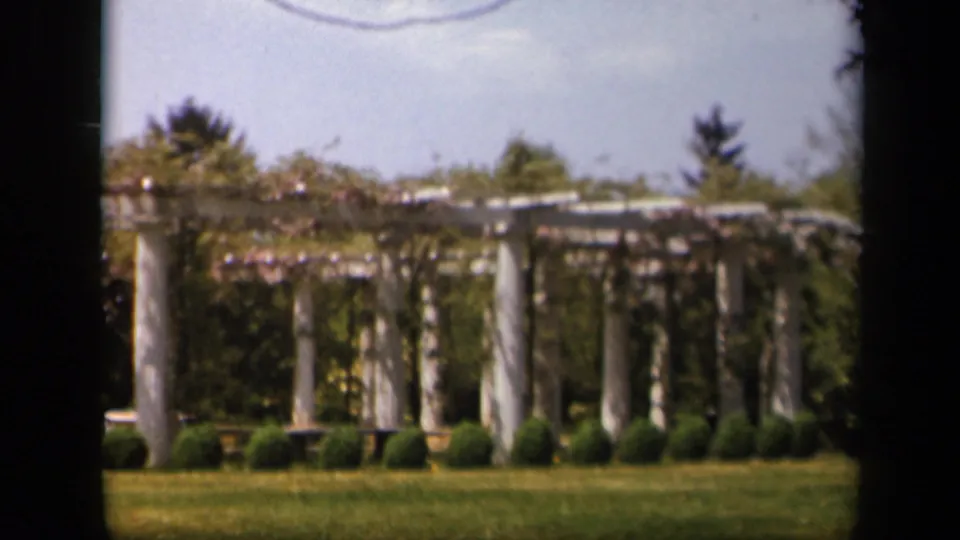 A similar 1943 Skyline Drive garden view shows the pergola, clipped greenery, lawn, and distant trees in soft 8mm color.