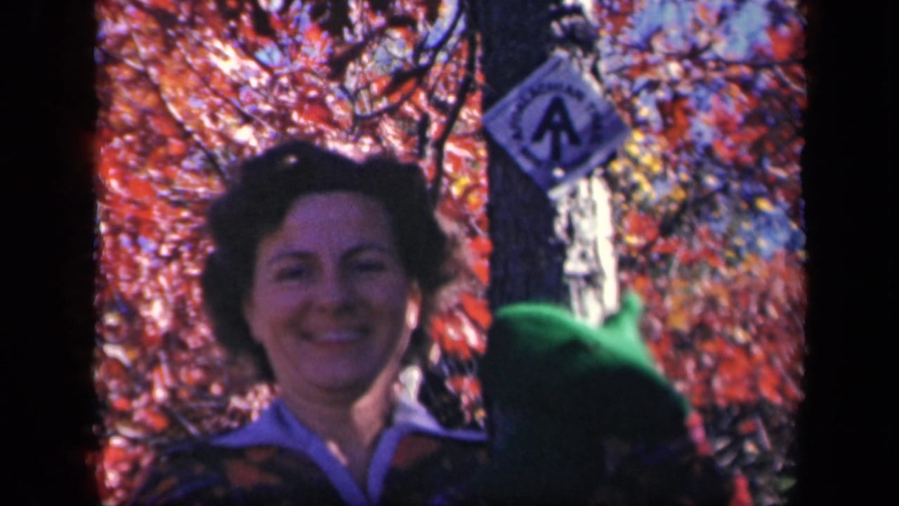 At Skyline Drive in 1943, the woman smiles toward the camera near a tree marked with a diamond sign and surrounded by fall color.