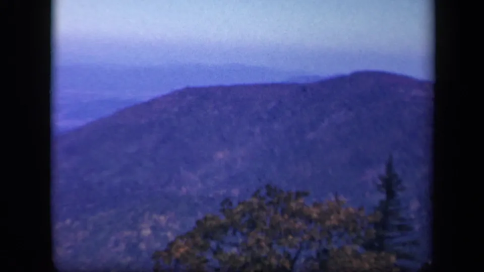 The final frame holds on a hazy Virginia mountain overlook, with ridgelines, treetops, and dark 8mm borders.