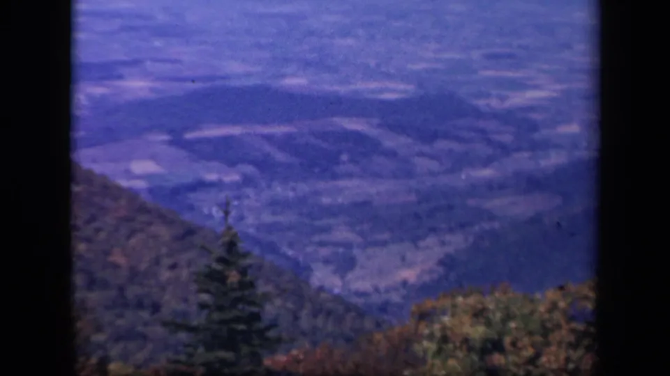 1943 8mm view from Skyline Drive showing wooded Virginia ridges and a distant valley beyond autumn trees.