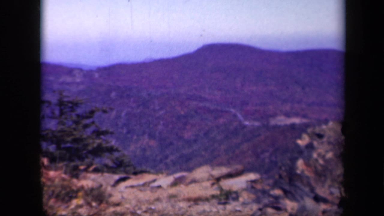 Skyline Drive, Virginia view from 1943 footage, with distant wooded hills, foreground rocks, and soft 8mm color shift.