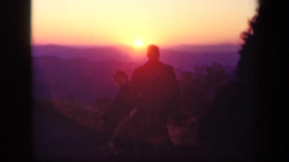 Two adults appear in silhouette against a purple-orange sunset at Skyline Drive, Virginia, in 1943 home-movie footage.