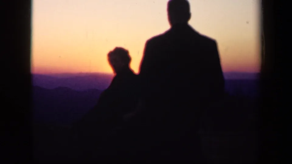 8mm frame from the 1943 Skyline Drive clip showing silhouetted family members beside a glowing mountain horizon.