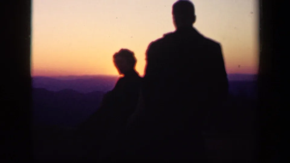 Final frame of a 1943 Skyline Drive home movie, with family silhouettes facing a purple-orange mountain sunset.