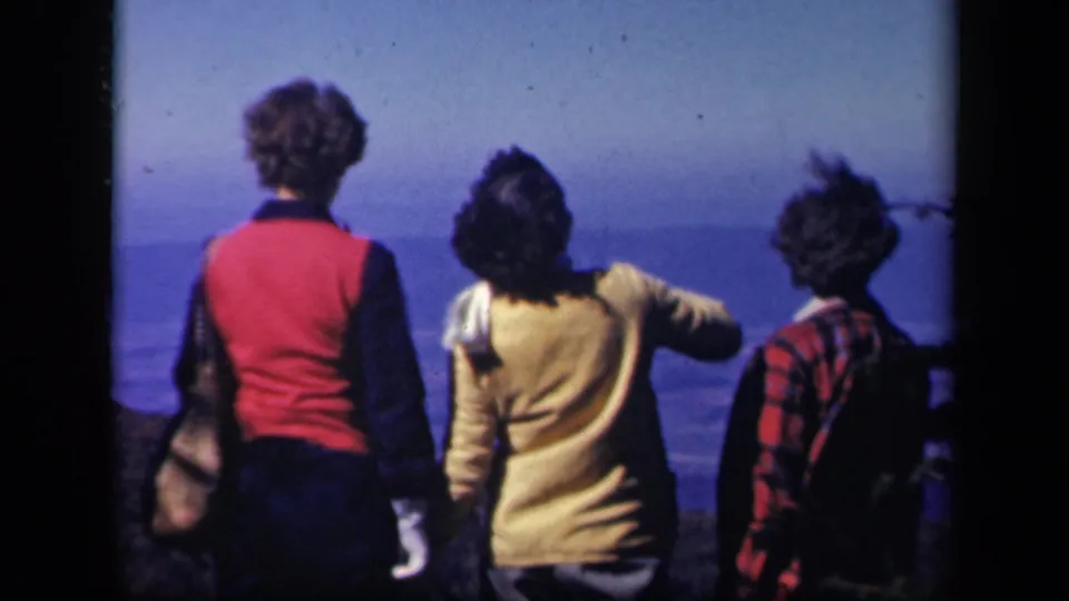 Three women at a Virginia scenic overlook face away from the camera, with one arm lifted toward the distant landscape.