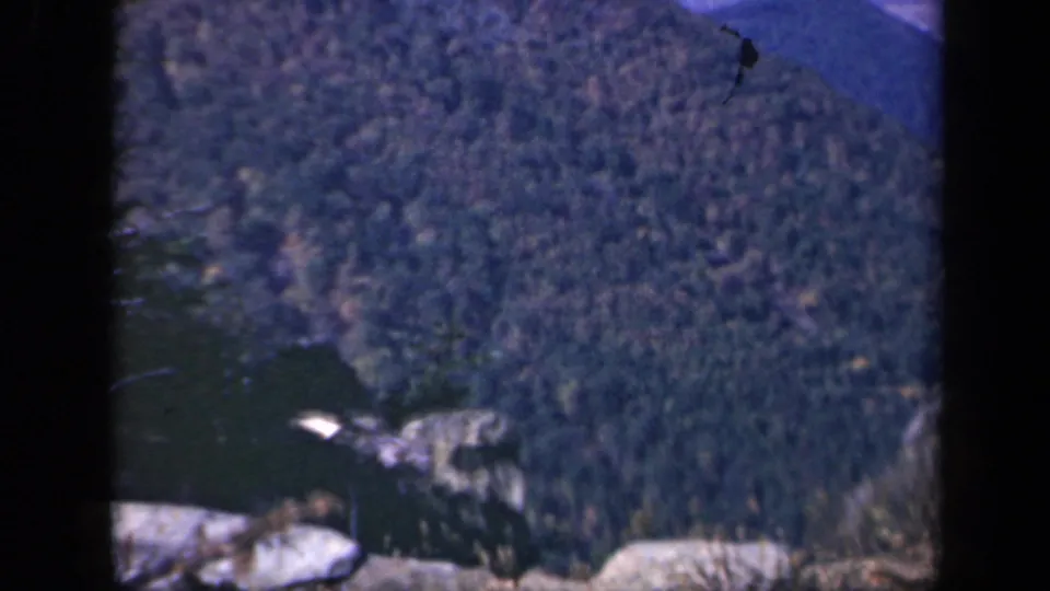 Skyline Drive overlook frame showing pale rocks in the foreground and a wooded Blue Ridge slope beyond.