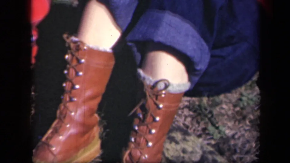 Lower legs in rolled blue jeans and tall brown lace-up boots appear in 1943 Skyline Drive home-movie footage.