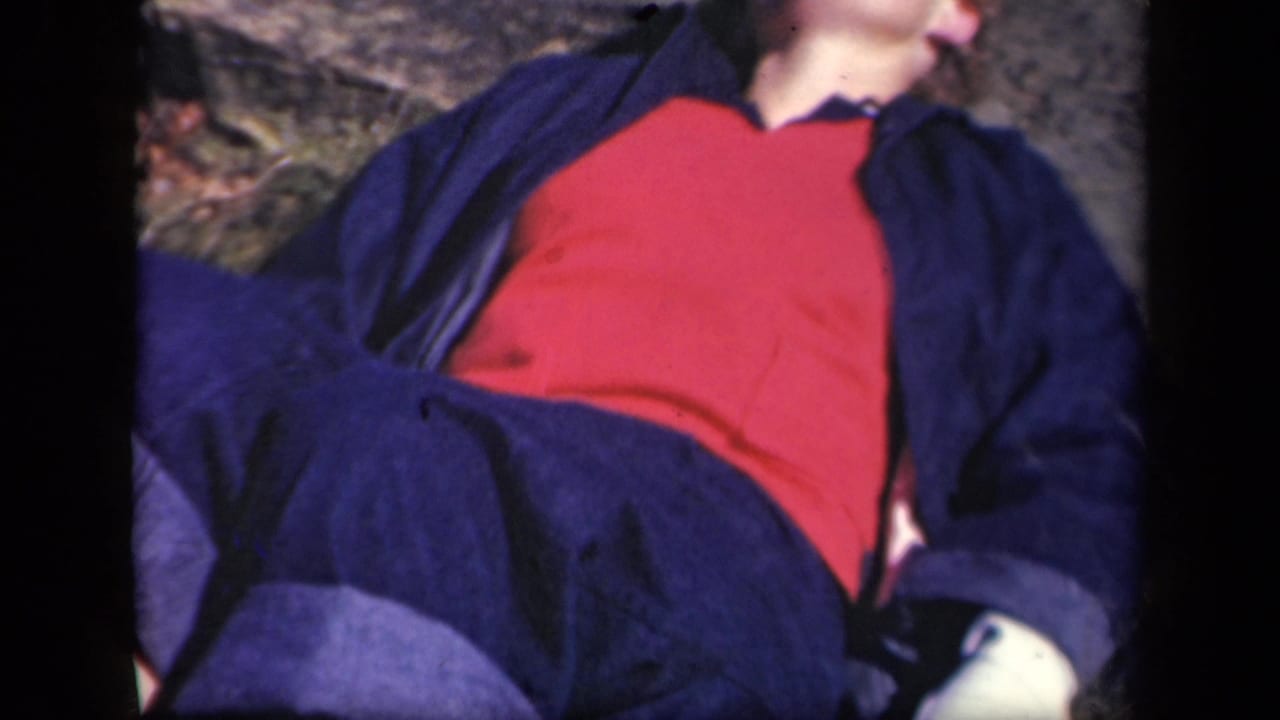 Close view of a woman reclining outdoors in red and dark clothing.