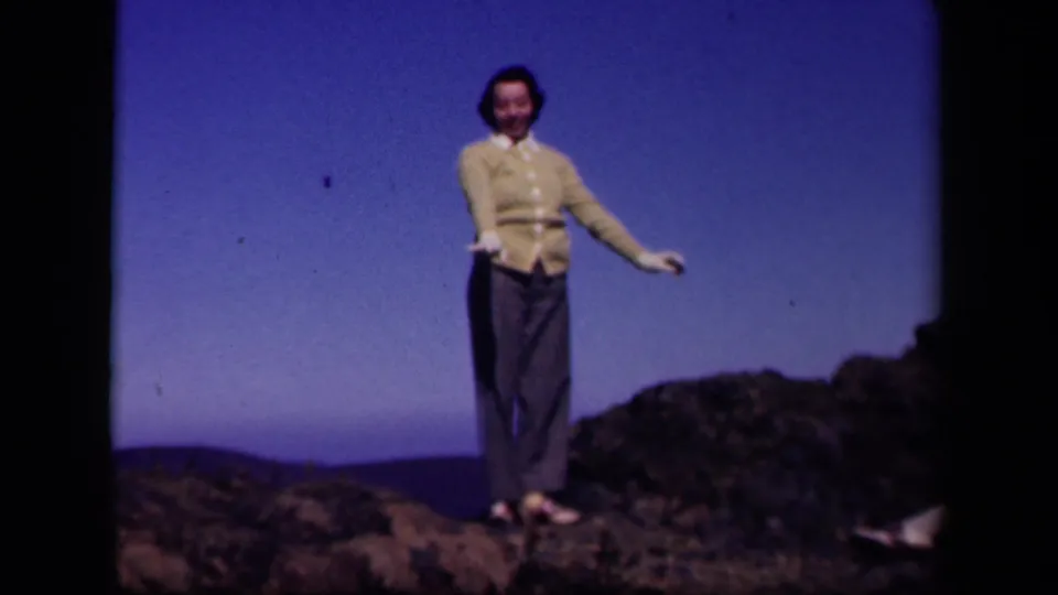 A smiling woman faces the camera during a playful movement on the Skyline Drive ridge.