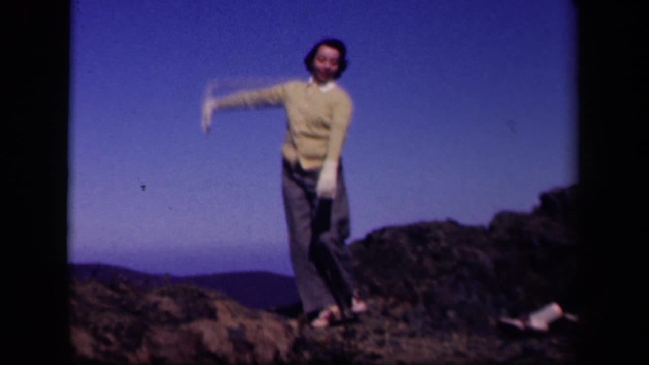 At Skyline Drive, Virginia in 1943, a woman in white gloves dances on rocky ground with hills behind her.