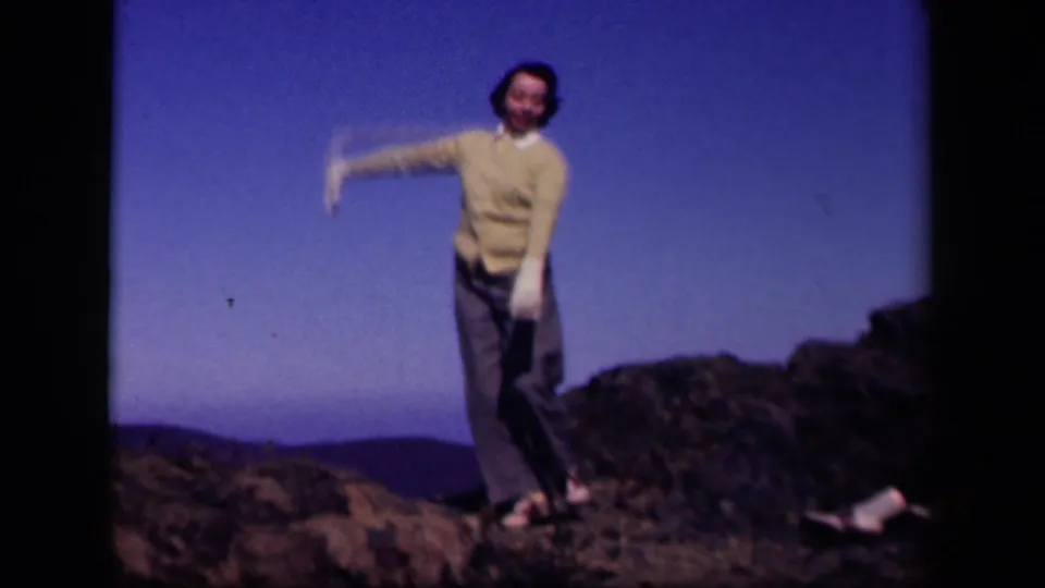 At Skyline Drive, Virginia in 1943, a woman in white gloves dances on rocky ground with hills behind her.