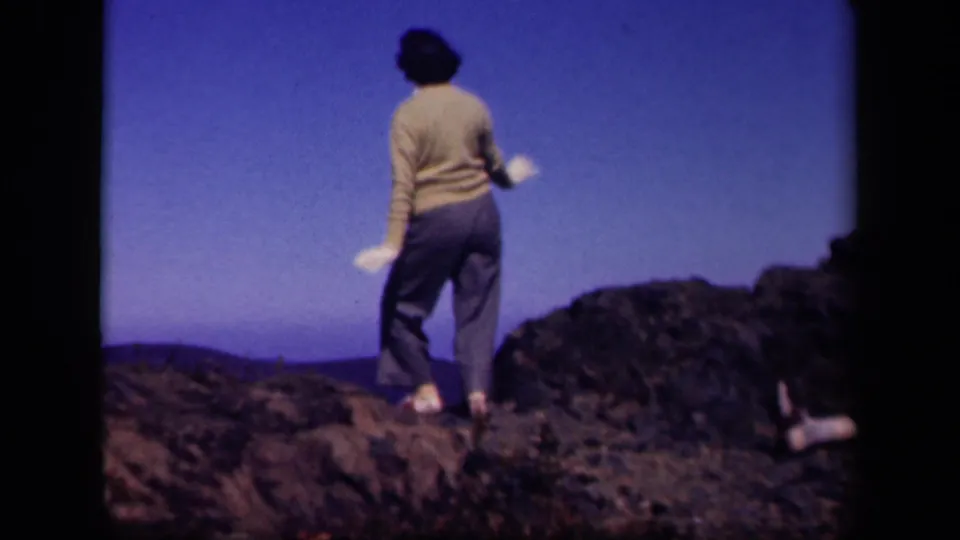 The 1943 Skyline Drive home movie shows the woman stepping and turning on rocks, seen mostly from behind.