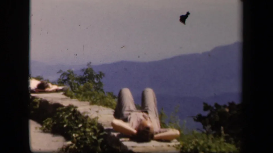 A wider Skyline Drive view places the reclining person along the lower edge, with the mountain landscape filling the background.