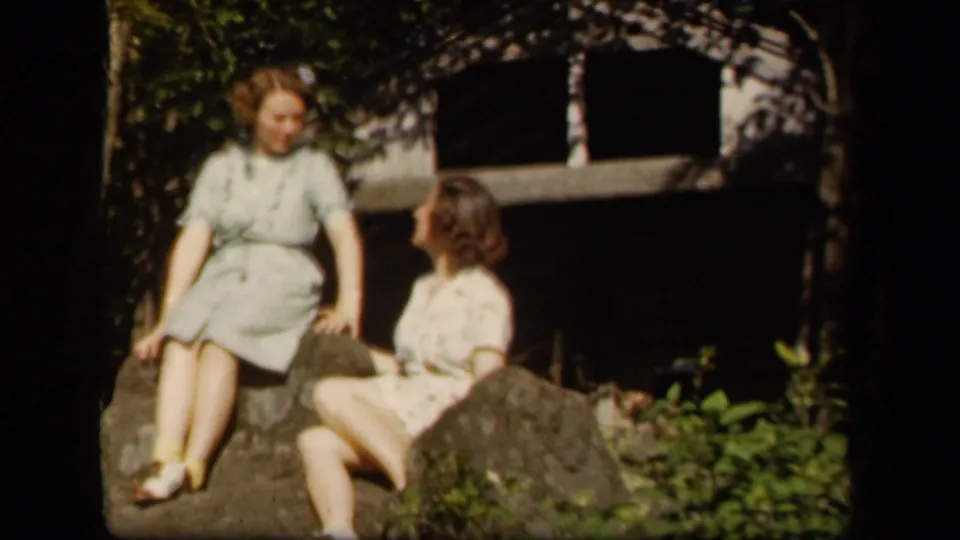 Two adult women in 1940s-style dresses relax on rocks outdoors at the supplied Skyline Drive, Virginia location.