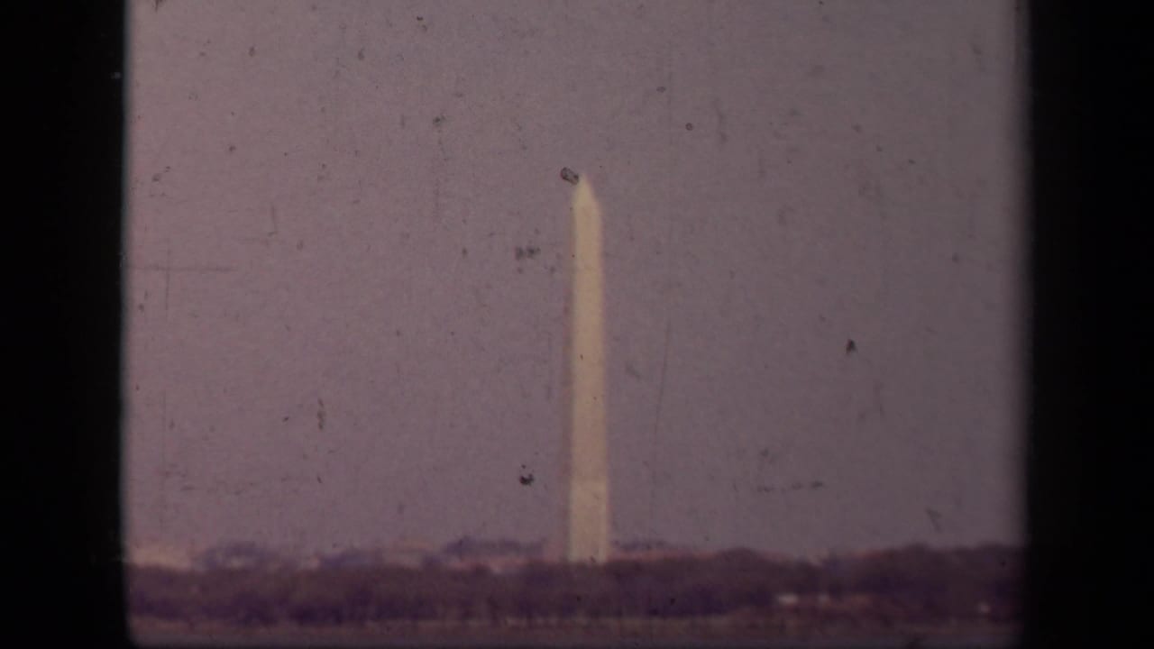 1943 Washington, DC home-movie frame showing the Washington Monument in soft focus beneath a hazy sky.