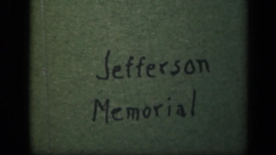 Close view of a handwritten Jefferson Memorial label on green material, likely part of the home-movie reel documentation.