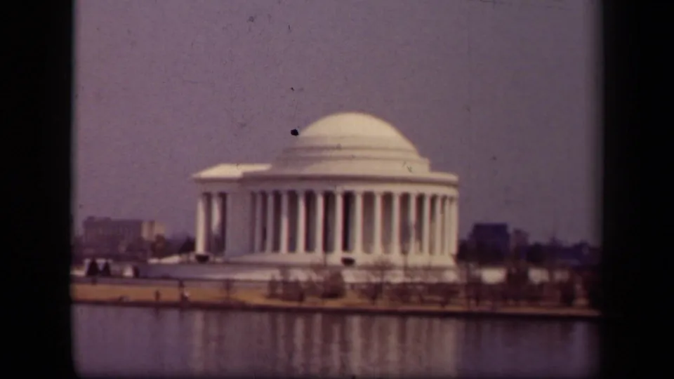 1943 8mm frame of the Jefferson Memorial in Washington, D.C., showing the dome and columns above the Tidal Basin shoreline.