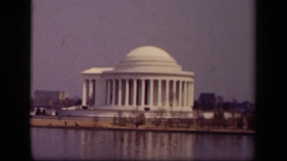 Soft 8mm frame of the Jefferson Memorial and Tidal Basin, with muted color and bare trees along the shore.
