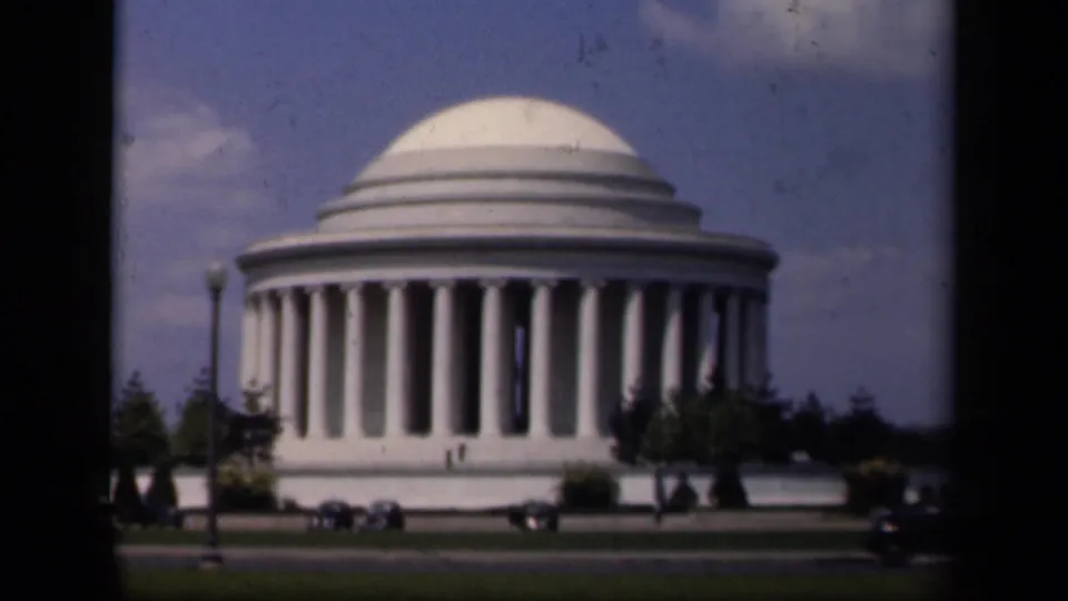 Closer 1943 Washington, DC view of the Jefferson Memorial with a lamppost, lawn, parked cars, and small visitors visible.