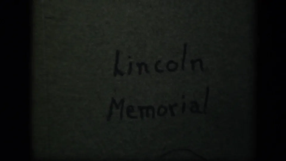 1943 8mm home-movie title card for the Lincoln Memorial, with handwritten text on aged green paper and visible film borders.