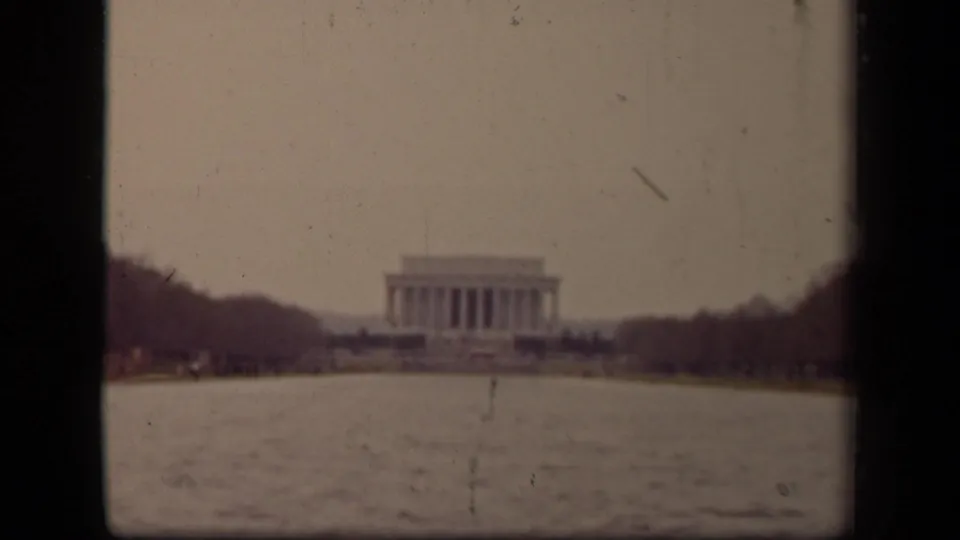 1943 8mm view of the Lincoln Memorial across the Reflecting Pool in Washington, DC, framed by soft focus and film edges.