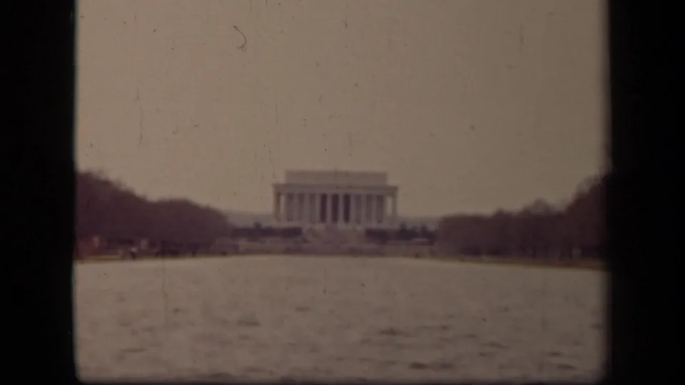 Final frame holds the Lincoln Memorial across the Reflecting Pool in Washington, DC, with faded color and home-movie softness.