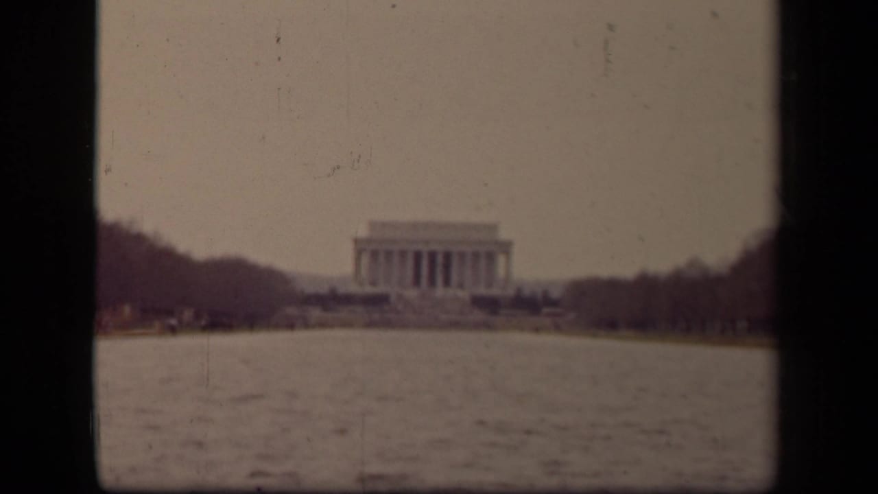1943 Washington DC home-movie frame showing the Lincoln Memorial in the distance beyond the Reflecting Pool and bare trees.