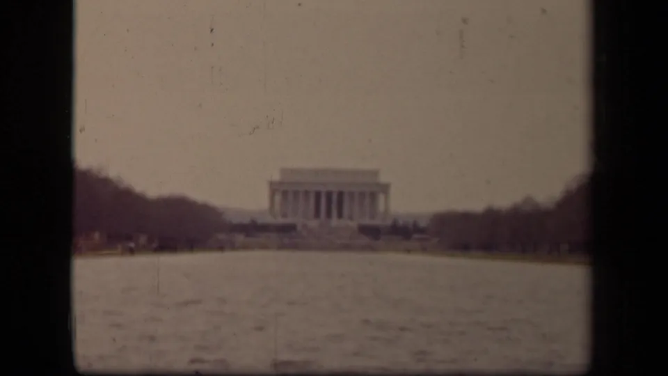 1943 Washington DC home-movie frame showing the Lincoln Memorial in the distance beyond the Reflecting Pool and bare trees.