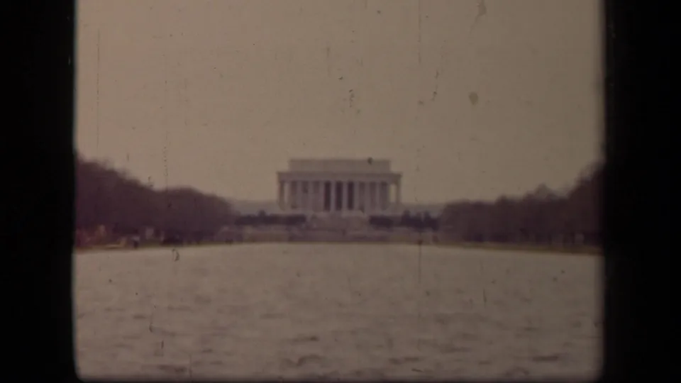 Distant 1943 view of the Lincoln Memorial across the Reflecting Pool, framed by dark film edges and winterlike tree lines.