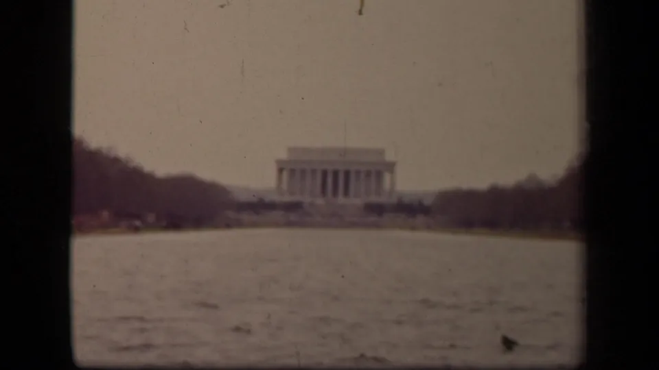 1943 Washington DC frame with the Lincoln Memorial partly softened in the distance beyond the Reflecting Pool and bare trees.