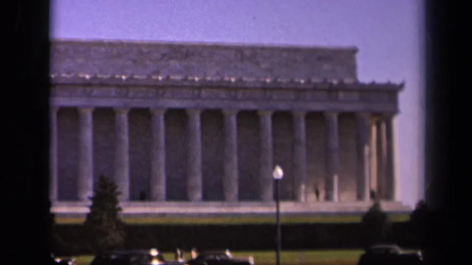 1943 Washington DC view of the Lincoln Memorial with its colonnade, lawn, lamppost, and mid-century cars near the foreground.